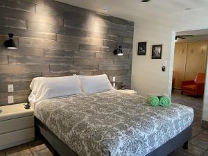 a bedroom with a bed with a wooden accent wall at Desert Paradise - A Men's Clothing Optional Resort in Palm Springs +22 photos