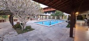 a swimming pool in a courtyard with people in it at Flat Divina Paz Monte Castelo in Sairé