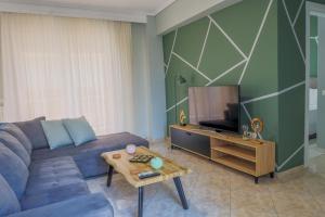 a living room with a blue couch and a tv at The perfect apartment 2 in Thessaloniki