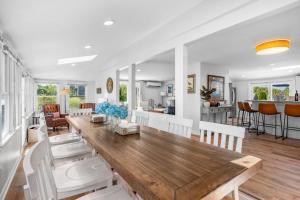 a dining room and living room with a wooden table at 128 Lower County Road Dennis - The Moor-a-Sea in West Dennis
