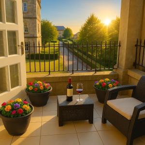 ein Balkon mit einem Glas Wein und Blumen in der Unterkunft St Andrews Apartments in Maidstone
