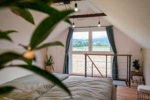 施皮尔贝格Tiny House Spielberg的一间卧室，里面有一张床和一扇大窗户。