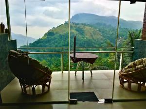 a balcony with a table and chairs and a mountain at Ella HIDE VIEW in Ella