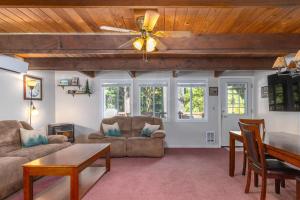 a living room with a ceiling fan and a table at Coal Creek Chalet | Creek, AC, Pet Friendly in Packwood