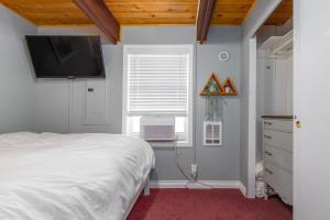 a bedroom with a bed and a television on the wall at Coal Creek Chalet | Creek, AC, Pet Friendly in Packwood