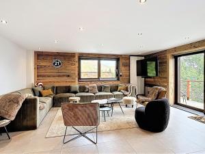 a living room with a couch and a tv at Chalet Savoyard de Luxe pour 14 personnes avec sauna et animaux admis - FR-1-267-311 in La Toussuire
