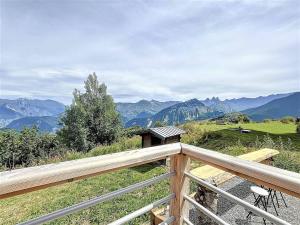 a wooden balcony with a view of mountains at Chalet Savoyard de Luxe pour 14 personnes avec sauna et animaux admis - FR-1-267-311 in La Toussuire