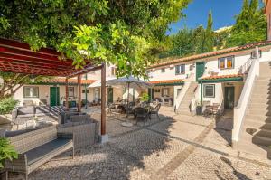 un patio con tavoli, sedie e un ombrellone di Alfama Terrace a Lisbona