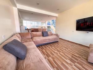 a living room with a large couch and a flat screen tv at Hotel Krammer en San Ramón, Selva Central in San Ramón