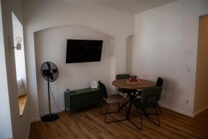 a dining room with a table and chairs and a fan at Altstadtsuite Landsberg am Lech in Landsberg am Lech