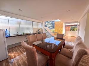 a living room with a table and chairs and a kitchen at Hotel Krammer en San Ramón, Selva Central in San Ramón
