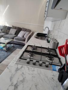 a kitchen with a stove top oven next to a couch at 2 Beds Suburb Nestled Nook in Manchester