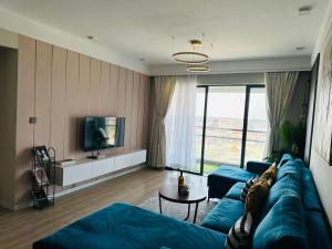 a living room with a blue couch and a tv at Homely Haven 2 Bedroom Near JKIA in Nairobi