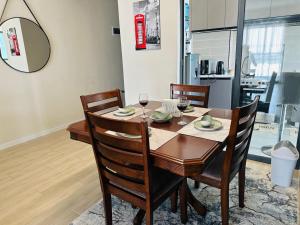 a dining room table and chairs with wine glasses at Homely Haven 2 Bedroom Near JKIA in Nairobi
