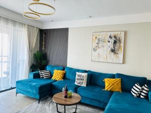 a living room with a blue couch and a table at Homely Haven 2 Bedroom Near JKIA in Nairobi
