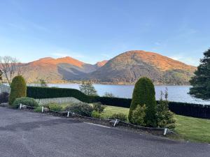 a driveway with a view of a lake and mountains at Allt Nan Ros Cottage in Fort William