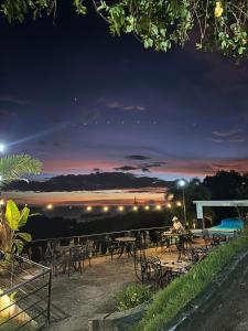 a group of tables and chairs at night at Bethany Hill Resort And Restaurant in Almeria