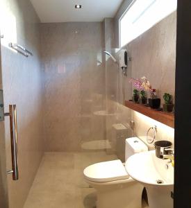 a bathroom with a toilet and a sink and a shower at Bethany Hill Resort And Restaurant in Almeria