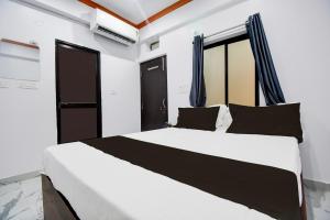 a bedroom with a large white bed with black pillows at Hotel O Moon Light in Patna