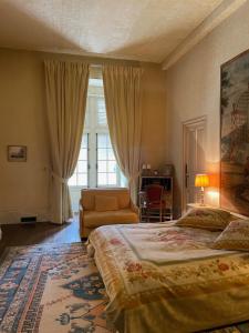 ein Schlafzimmer mit einem Bett und einem Stuhl und einem Fenster in der Unterkunft Château de Montigny-sur-Aube in Montigny-sur-Aube