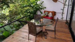 PapagallerosNatural Luxury Birding Lodge的木甲板上的玻璃桌子和椅子