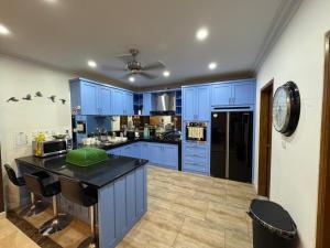a kitchen with blue cabinets and a black counter top at Villa Munjul Indah - Majalengka in Jatipamor