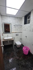 a dirty bathroom with a sink and a toilet at Hotel Vaishno Regal in Bhubaneshwar