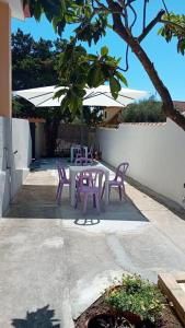 a table and chairs under an umbrella on a patio at L'oasi - Monolocale con giardino in Sardegna in Carbonia