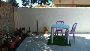 two purple chairs and a table in a yard at L'oasi - Monolocale con giardino in Sardegna in Carbonia +4 photos