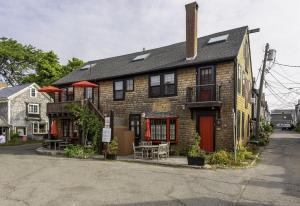 ロックポートにあるThe Perch featuring Elevated Harbor Views in Rockportの赤い扉のあるレンガ造りの家