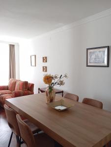a dining room table with a vase of flowers on it at Cardenal Centro in Monforte de Lemos