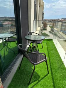 a table and chairs on a balcony with green grass at Квартира в SEEBREZE in Nardaran
