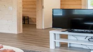 a large flat screen tv sitting on a white table at Chalet Magical Forest Harjunpolku Lapland in Rovaniemi