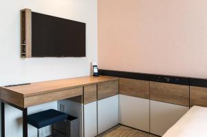 a room with a desk with a television on a wall at New Star Hotel Lahore in Lahore