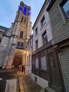 a church with a clock tower and a building at Maison Médiévale LAON in Laon