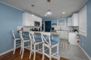 a kitchen with blue walls and white cabinets and stools at Cozy 3-Bedroom Retreat in Charming Beaufort, SC in Beaufort