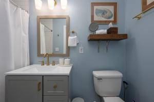 a bathroom with a toilet and a sink and a mirror at Cozy 3-Bedroom Retreat in Charming Beaufort, SC in Beaufort +29 photos