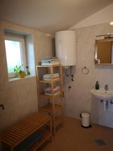 a bathroom with a sink and a shelf with towels at Holiday house Catela in Rakalj