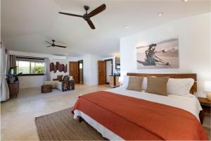 a bedroom with a bed and a ceiling fan at Hale Holawa Mana-Oceanfront Sunset Beach in Haleiwa