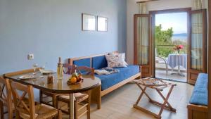 a living room with a blue couch and a table at Hotel Apartments Sikia in Kato Gatzea