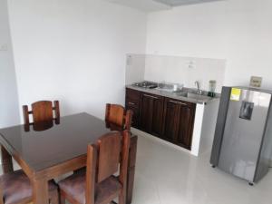 a kitchen with a table and a stainless steel refrigerator at Hotel Tania in Caucasia