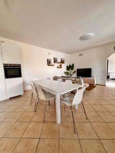 een witte tafel en stoelen in de woonkamer bij Casa Agata - La Casa in Sardegna in Tortolì