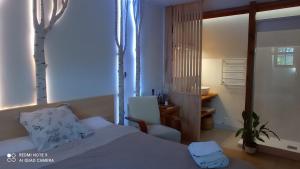 a bedroom with a bed and a chair and trees at Bet & Jac in Meyronne