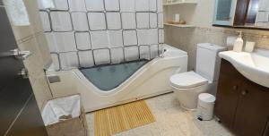 a bathroom with a tub next to a toilet and a sink at Harmony House in Faliraki +19 photos