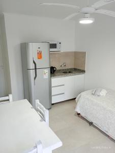 a kitchen with a refrigerator and a bed in a room at Concepción Termal - Acceso preferencial a Termas in Federación