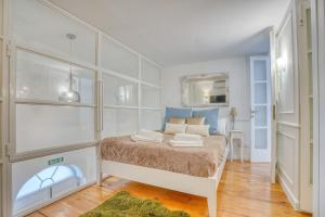 a bedroom with a bed with white walls and a mirror at Modern Oasis Near Mdina with Rooftop Pool & View in Rabat