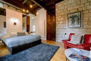 a living room with a bed and a red couch at La Maison du Prevot - Maison d hotes de charme au pied de la Cathedrale Sainte Cecile d Albi La Maison du Prevot - Charming Guesthouse at Foot of Albi Cathedral in Albi