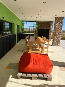 a wooden table and chairs in a room with a table and a table at Casona Islas Blancas in Camarones
