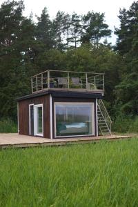 a house with a balcony on top of a field at Angervaksa LoodusSpa in Laugu