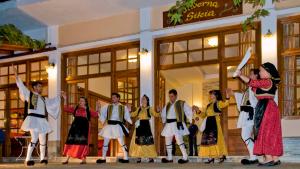 a group of people dancing in front of a store at Hotel Apartments Sikia in Kato Gatzea